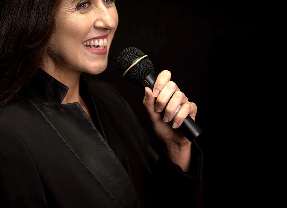 Elin Wyn speaking into a microphone during a media appearance